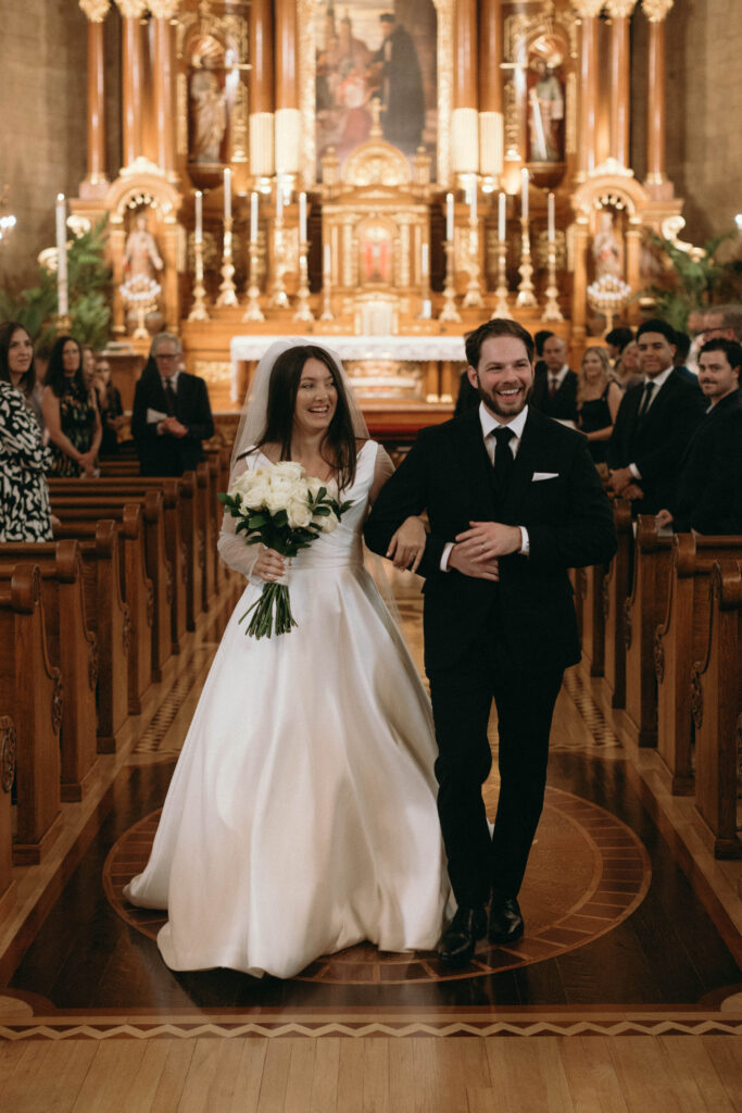 A bride and groom walking down the aisle of St. John Cantius